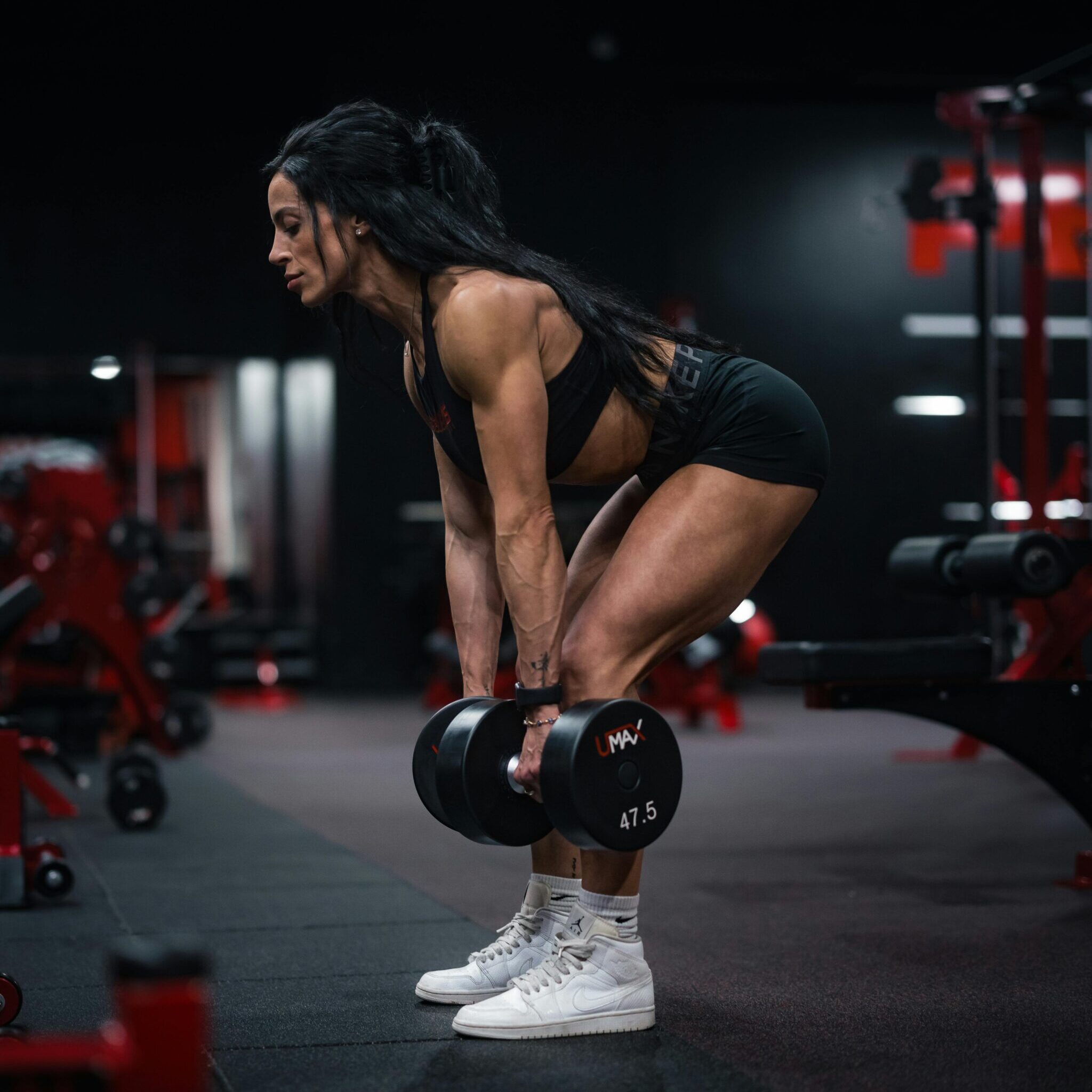 female athlete performing dumbbell deadlift for muscle building and strength training in gym South Africa