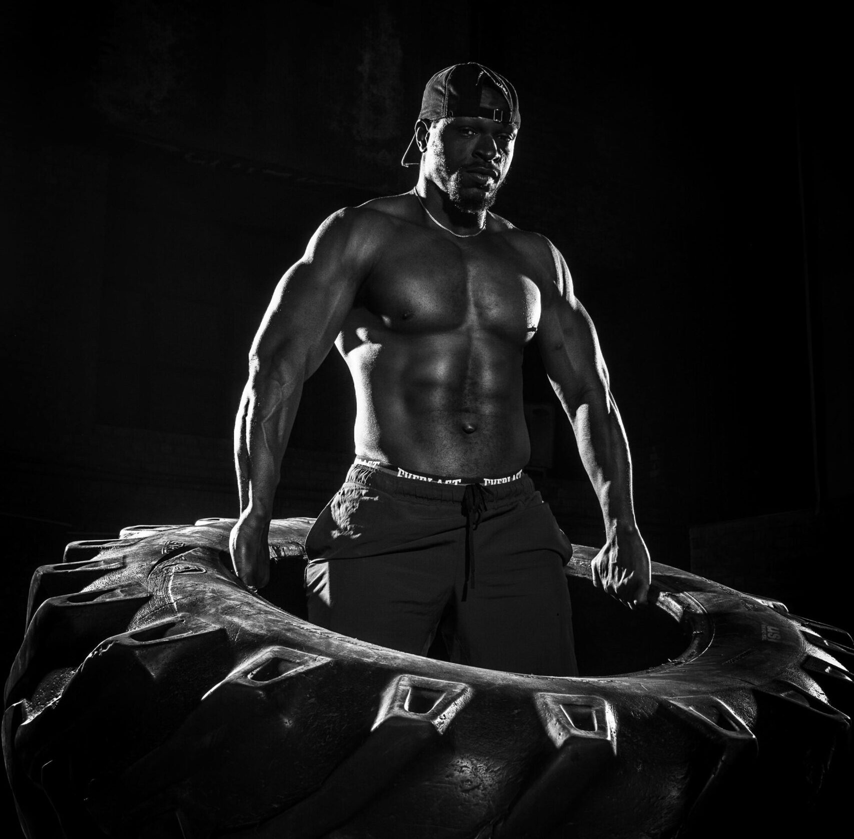 bodybuilder doing tire flip for power and performance training