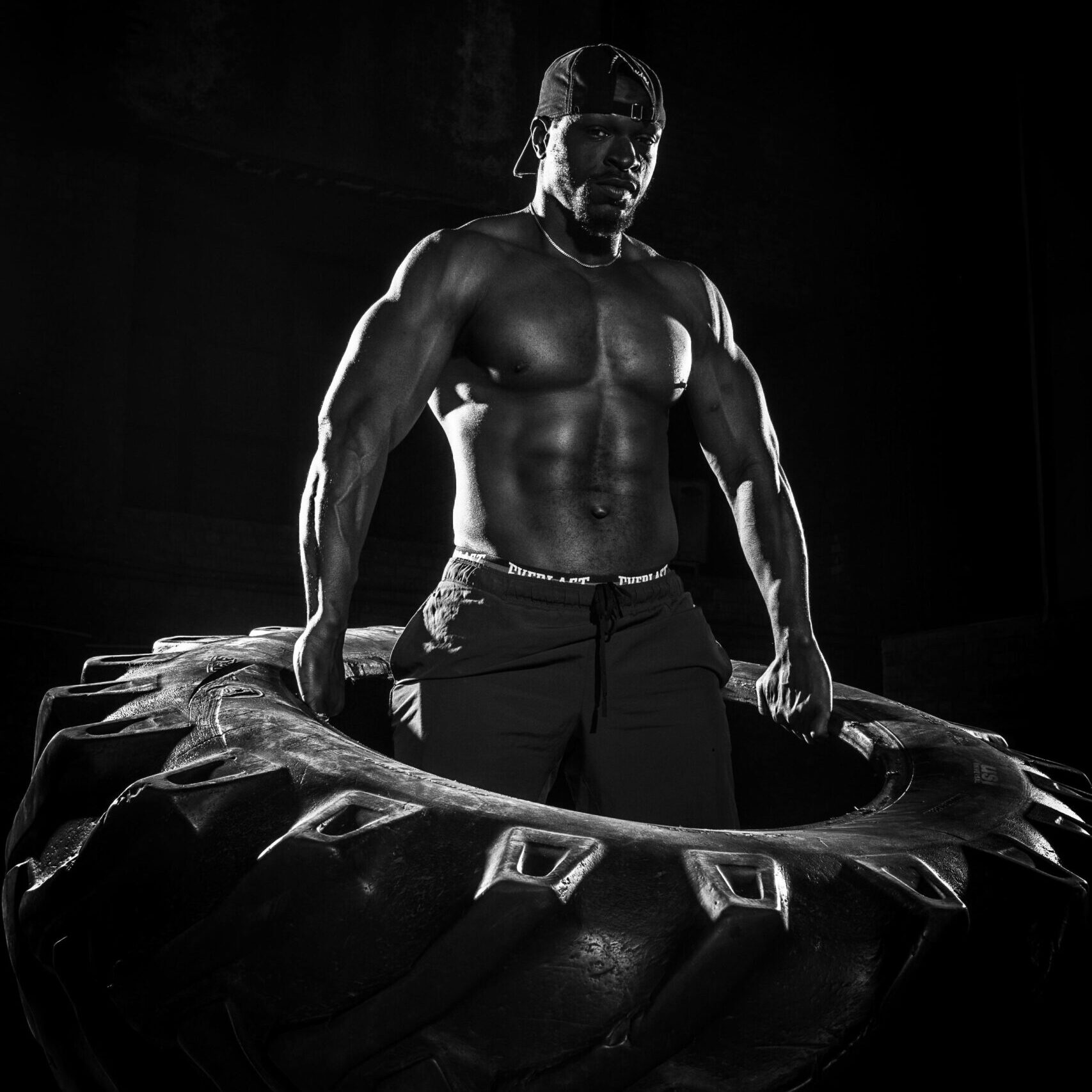 bodybuilder doing tire flip for power and performance training